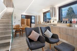 a living room with two chairs and a kitchen at Charmingly Renovated Stone House in Cesara