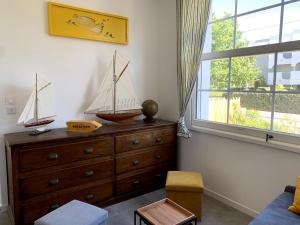a room with a dresser and a dresser with two model boats on it at Appartement bord de plage-Arcachon in Arcachon