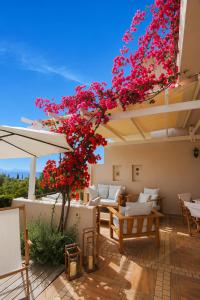 a patio with a tree with pink flowers on it at Pentathlon Villa Collection - Porto Cheli Private Pool Getaways in Porto Heli