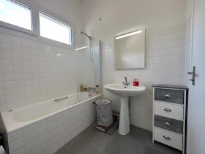 a bathroom with a sink and a bath tub and a sink at Appartement bord de plage-Arcachon in Arcachon +30 photos