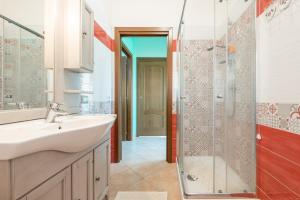 a bathroom with a sink and a shower at Villetta Delfino in Sìnnai +20 photos