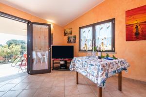 a living room with a table and a tv at Villetta Delfino in Sìnnai