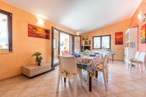a dining room with a long table and chairs at Villetta Delfino in Sìnnai