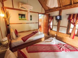 a bedroom with two beds and a television in it at Phuphaya Seaview Adults Only in Phi Phi Islands
