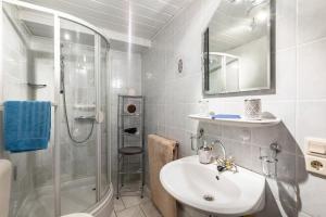 a white bathroom with a sink and a shower at Appartment Schlossmühle in Olsberg in Olsberg +16 photos