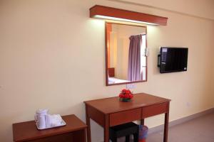 a hotel room with a table and a mirror at Sun Inns Setiawan in Sitiawan
