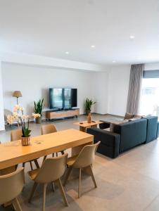 a living room with a table and a couch at White luxury apartment in Tríkala