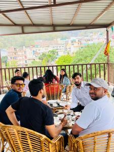 a group of people sitting at a table at Hotel Mount View Inn with terrace Ganga view- near Laxman jhula, Tapovan Rishikesh in Rishīkesh