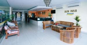 a lobby of a sun inn with chairs and a table at Sun Inns Setiawan in Sitiawan