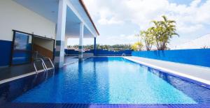 a swimming pool in a house with a blue wall at Sun Inns Setiawan in Sitiawan
