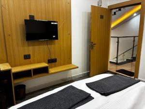 a bedroom with a bed and a tv on a wall at Shri Radha Kripa Dham in Rādha Kund