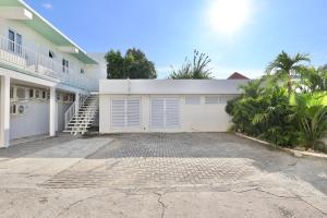a white house with a driveway and a staircase at Alesea Suites Surf Town in Dalumpinas Oeste