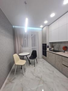 a kitchen with a table and two chairs and a counter at Апартаменти Центр in Lutsk