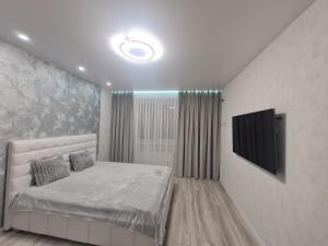 a bedroom with a bed and a flat screen tv at Апартаменти Центр in Lutsk