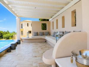 a patio with couches and a swimming pool at Pentathlon Villa Collection - Porto Cheli Private Pool Getaways in Porto Heli