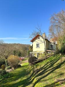 a yellow house on a grassy hill with a house at Maison Robinson in Yport