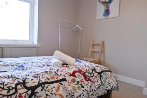a bedroom with a bed with a comforter and a chair at 7 Western Hill in Frosterley