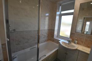 a bathroom with a tub and a sink and a shower at 7 Western Hill in Frosterley