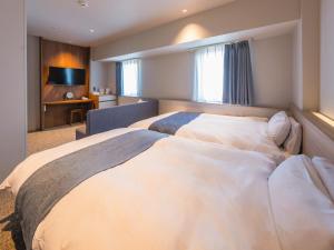 a hotel room with a large bed and a television at New Osaka Hotel in Osaka