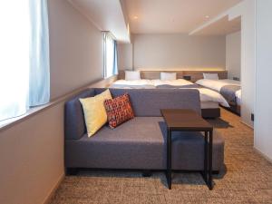 a living room with a couch and a bed at New Osaka Hotel in Osaka
