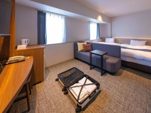 a hotel room with a bed and a couch at New Osaka Hotel in Osaka