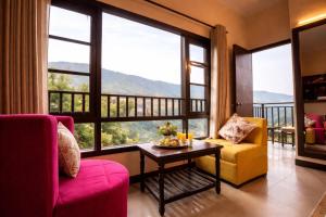 a living room with a table and chairs and large windows at Aachman Regency Shimla Mallroad in Jutogh +11 photos
