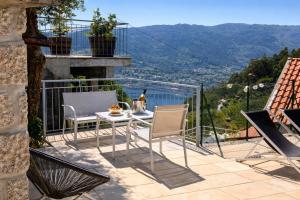 a patio with two chairs and a table with a view at Casa da Lage - Piscina privada - Vistas rio - "Gerês" in Geres