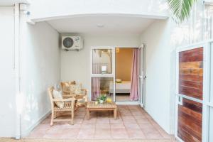 a patio with chairs and a table and a table at Bois Bleu Bed And Breakfast in Tamarin