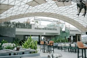 a restaurant with tables and chairs in a building at Atmosfera Bengaluru, India in Bangalore