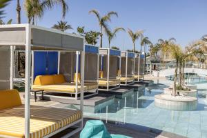 a row of beds on a building with palm trees at Faros Hotel Ayia Napa in Ayia Napa