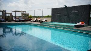 a large swimming pool with blue water at Flora Airport Hotel and Convention Centre Kochi in Nedumbassery