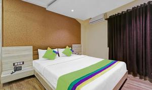 a bedroom with a large bed with a rainbow blanket at Hotel Apollo in Guwahati +6 photos