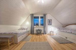 a attic room with two beds and a window at Gästeapartment Hannover in Hannover