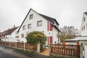 a white house with a wooden fence in front of it at Gästeapartment Hannover in Hannover