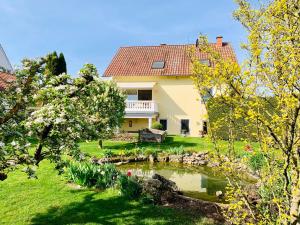 a house with a pond in the yard at Ferienwohnung mit Terrasse, Garten in Gotha