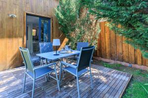 a blue table and chairs on a wooden deck at Loc Ty Home in Soustons