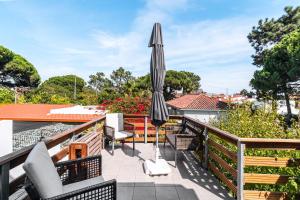 a patio with an umbrella and chairs on a balcony at Rebelsardine in Charneca