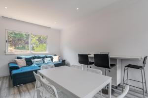 a living room with a blue couch and a table at Rebelsardine in Charneca