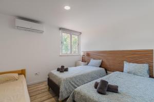 a bedroom with two beds and a window at Rebelsardine in Charneca +25 photos