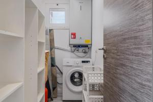 a small bathroom with a washing machine in it at Rebelsardine in Charneca