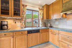a kitchen with wooden cabinets and a window at Ferienhaus mit Bergpanorama in Unterwössen +19 photos