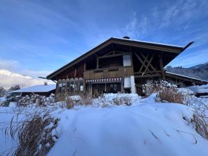 a log cabin in the snow with snow covered plants at Ferienhaus mit Bergpanorama in Unterwössen