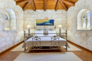 a bedroom with a bed in a stone wall at Villa Ira in Agios Leon +37 photos
