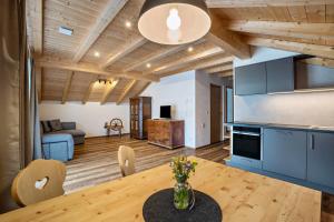 a kitchen and living room with a wooden ceiling at Krämerhof Apt Aferer Geisler in Rodengo