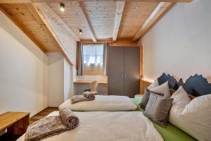 two beds in a room with wooden ceilings at Krämerhof Apt Aferer Geisler in Rodengo