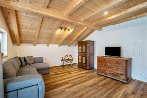 a living room with a couch and a tv at Krämerhof Apt Aferer Geisler in Rodengo