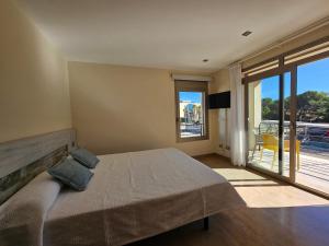 a bedroom with a large bed and a balcony at Antonia in Can Picafort