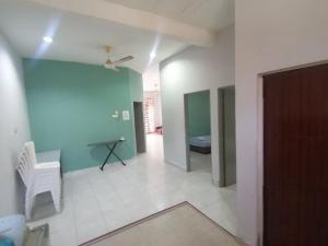 a room with a blue wall and a table and a chair at Promenade Homestay 2 in Kampong Sura Masjid +31 photos