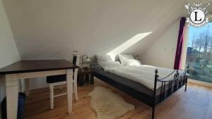 a bedroom with a bed and a desk and a window at Landhaus Ferien Ostsee in Sterup