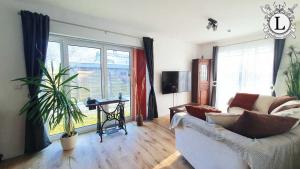 a living room with a couch and a large window at Landhaus Ferien Ostsee in Sterup